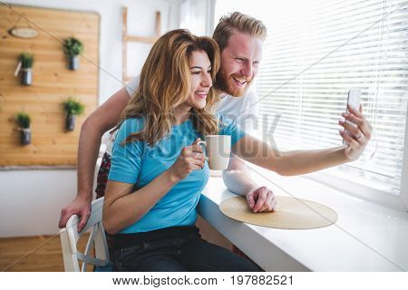 Romantic couple in love taking selfies and smiling at hime