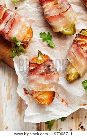 Jalapeno poppers wrapped in bacon stuffed with cheese seasoned with herbs and spices, top view