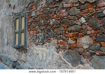 Old stones and bricks wall with old broken window