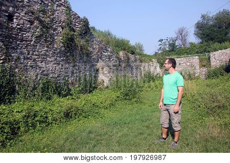 Tourist visiting ruins at Curtea Domneasca, Curtea de Arges, Romania