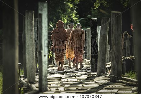 The monks walking on bamboo bridge at Meahongson Thailand.