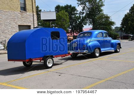 CASSELTON, NORTH DAKOTA, July 27, 2017: The annual Casselton Car Show which occurs the last Thursday of July features classic vehicles such as the restored 1948 Plymouth pulling a camper.