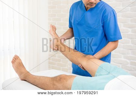 Physiotherapist training rehab exercise to broken leg patient in hospital