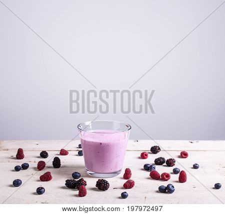 Yogurth with fresh berries on white table