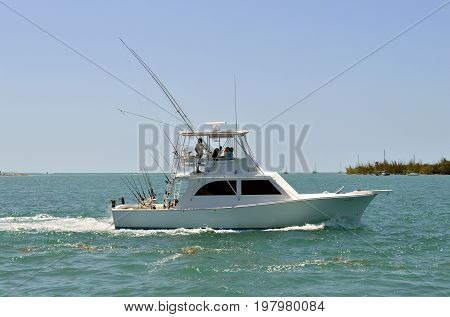 Sunset Key Florida Keys Florida USA - May 15 2017 : Fishing boat sailing past Sunset Key in Florida