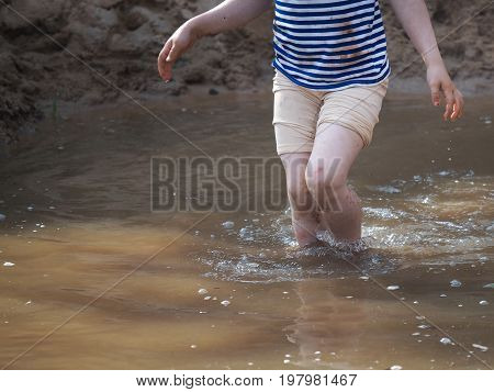 The baby's leThe baby's legs in the muddy water and sandgs in the muddy water and sand