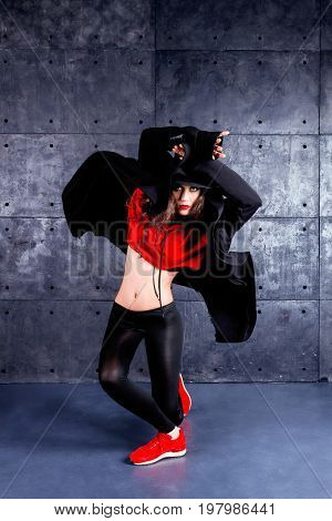Girl dancing in front of the urban wall.
