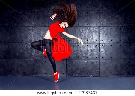 Girl dancing in front of the urban wall.