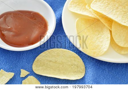 crispy and salt potato chips on dish dipping with ketchup
