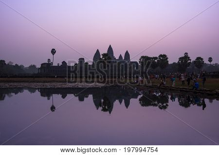 ANGKOR WAT CAMBODIA - JANUARY 28 2015: Tourists waiting for dawn at Angkor Wat temple in Cambodia. Angkor Wat is the largest Hindu temple complex and religious monument in the world