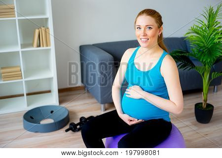 Pregnant woman doing pre-natal exercises at home