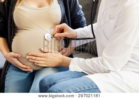 Closeup Of Unrecognizable Obstetrician Listening To Baby Heartbeat Putting Sthetoscope To Pregnant B
