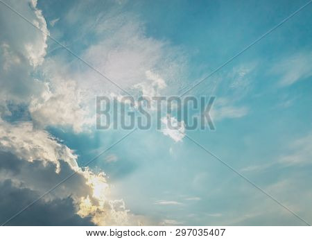 Dark Grey Cloud Cover The Sun. Sun Light Brusting Behind The Cloud. Blue Pastel Color Sky.