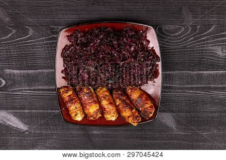 Fried Homemade Grilled Sausages Or Chevapchichi With Stewed Sauerkraut On A Wooden Rustic Background