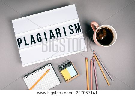 Plagiarism. Text In Light Box. Pink Coffee Mug On Gray Background