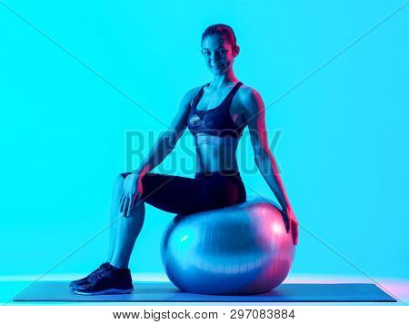 one mixed races woman exercsing fitness pilates exercices isolated on blue blackground