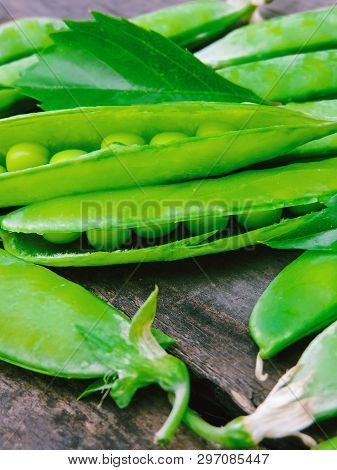 Fresh Green Peas On Wood Background.  Peas, Pods And Leaves Set. Healthy Food. Macro Shooting. Flowe
