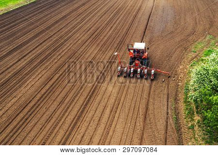 Aerial View Of Tractor With Mounted Seeder Performing Direct Seeding Of Crops On Plowed Agricultural