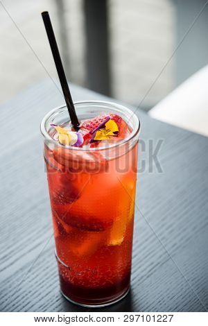 fresh lemonade with  straws with fresh strawberry and orange on a bar table