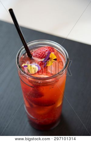 fresh lemonade with  straws with fresh strawberry and orange on a bar table