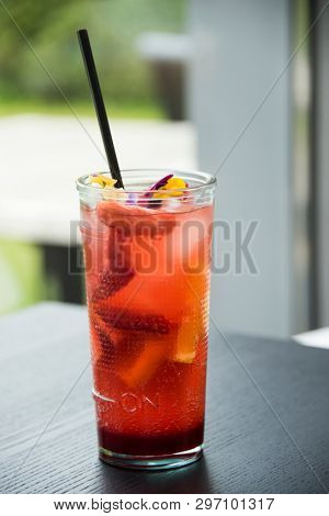 fresh lemonade with  straws with fresh strawberry and orange on a bar table
