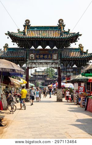 Aug 2013 - Pingyao, Shanxi, China - Tourists Walk Under A Carved Archway In One Of The Main Streets 