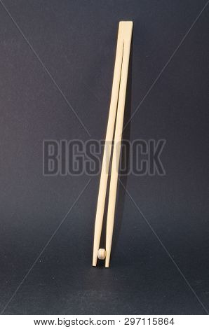 Chopsticks With Tablets Against A Black Background. Concept Of Health Costs And Drug Misuse.
