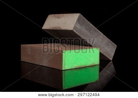 Group Of Two Whole Work Item Green And Grey Abrasive Block Sponges Isolated On Black Glass