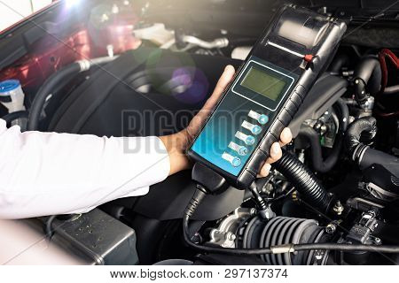 Man Inspection Holding Battery Capacity Tester Voltmeter.for Service Maintenance Of Industrial To En