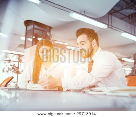 Skilled Business Couple Making Business Decisions In Snny Modern Office. Sitting At Desk. Business C