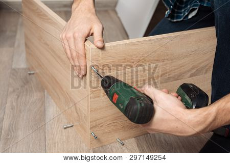 Assembling Furniture. Men's Hands With A Screwdriver To Collect New Furniture