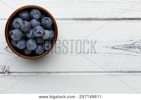 Blueberries In A Bowl On A Distressed White Wooden Background With Space For Copy