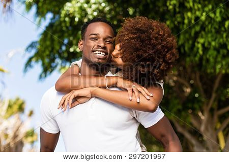 Outdoor Protrait Of Black African American Couple - Guy Carrying Girfriend On His Back