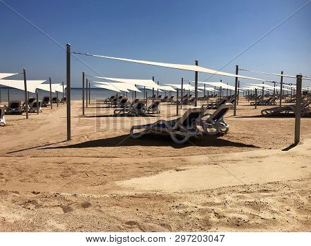 Stylish Lounger In Yellow Sand To Sun Sunbed On Beach In Summer Under Open Sky. Sunbed Intended For 