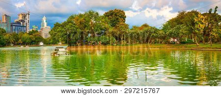 Panoramic view of Bangkok skyline, Thailand. View from Lumphini park. Pond on the foreground