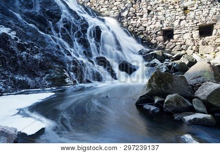 Beautful Waterfall In Blue Shades In The Swedish Village Rottle During Spring