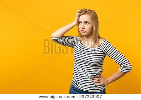 Portrait Of Preoccupied Young Woman In Striped Clothes Looking Aside Putting Hand On Head Isolated O