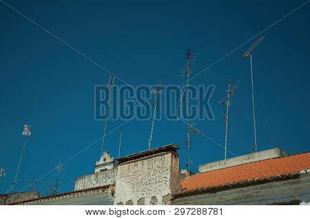 Set Of Television Antennas On Top Of Roof With Blue Sky In The Background At Campo Maior. A Cute Lit