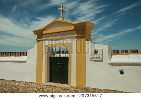 Evoramonte, Portugal - July 6, 2018. Colorful gateway in graveyard wall in the main street of Evoramonte. A tiny fortified civil parish over hill where stands out its historic castle in Portugal.