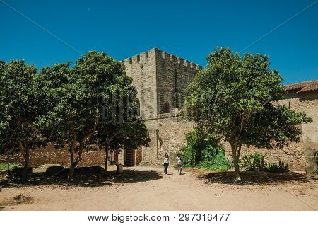Elvas, Portugal - July 7, 2018. Two women walking on a sunny day through the central courtyard at the Castle of Elvas. A gracious star-shaped fortress city on the easternmost frontier of Portugal.
