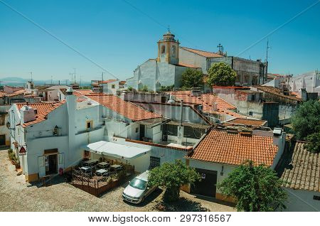 Elvas, Portugal - July 07, 2018. Cityscape with old houses and church steeple in front of street on a sunny day at Elvas. A gracious star-shaped fortress city on the easternmost frontier of Portugal.