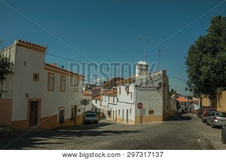 Old Colorful Houses In Front Of Deserted Street With Parked Cars