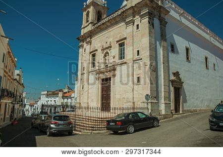 Campo Maior, Portugal - July 8, 2018. Church Facade In Front Of Street With Old Houses, On Sunny Day