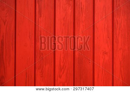 Old wooden background painted with red paint with a texture of cracks and scratches. Red background