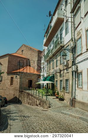 Covilha, Portugal - July 11, 2018. Restaurant Underneath Old House With Tables And Chairs On The Sid