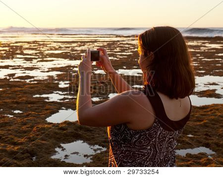 Dívka s Foto Sunset na telefonu