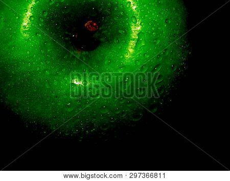 Green Ripe Apple With Water Droplets On A Dark Background, Closeup