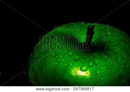 Green Ripe Apple With Water Droplets On A Dark Background, Closeup