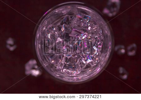 Glass Of Pure Water With Ice Cubes. View From Above. Abstract Dynamic Backdrop For Your Design