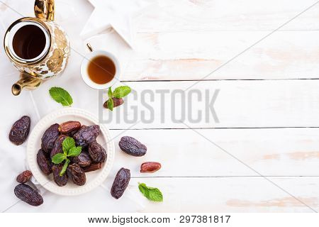 Ramadan Food And Drinks Concept. Tea With Dates Fruit And Mint Leaves On A White Wooden Table Backgr